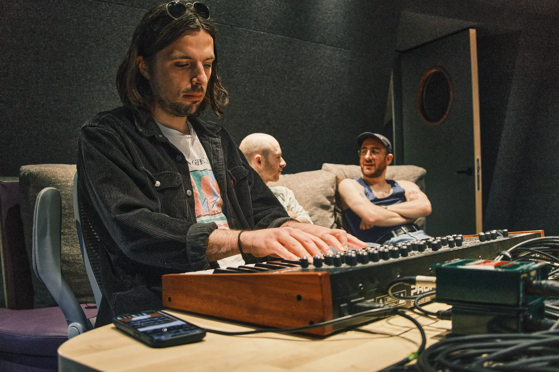 Producer working with a synthesizer in the control room
